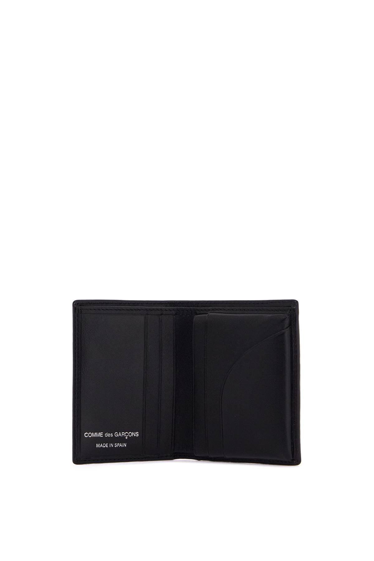 COMME DES GARCONS WALLET compact leather wallet with large eyelet.